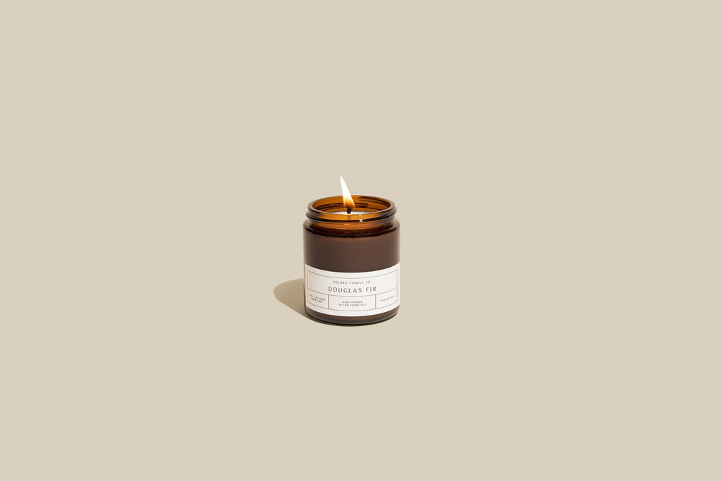 Douglas Fir candle glowing softly in a brown jar, capturing the essence of a crisp mountain breeze and forest fragrance.