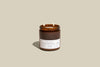 Toasted Chestnut + Rum scented candle in amber jar with two wicks, perfect for a cozy holiday ambiance.